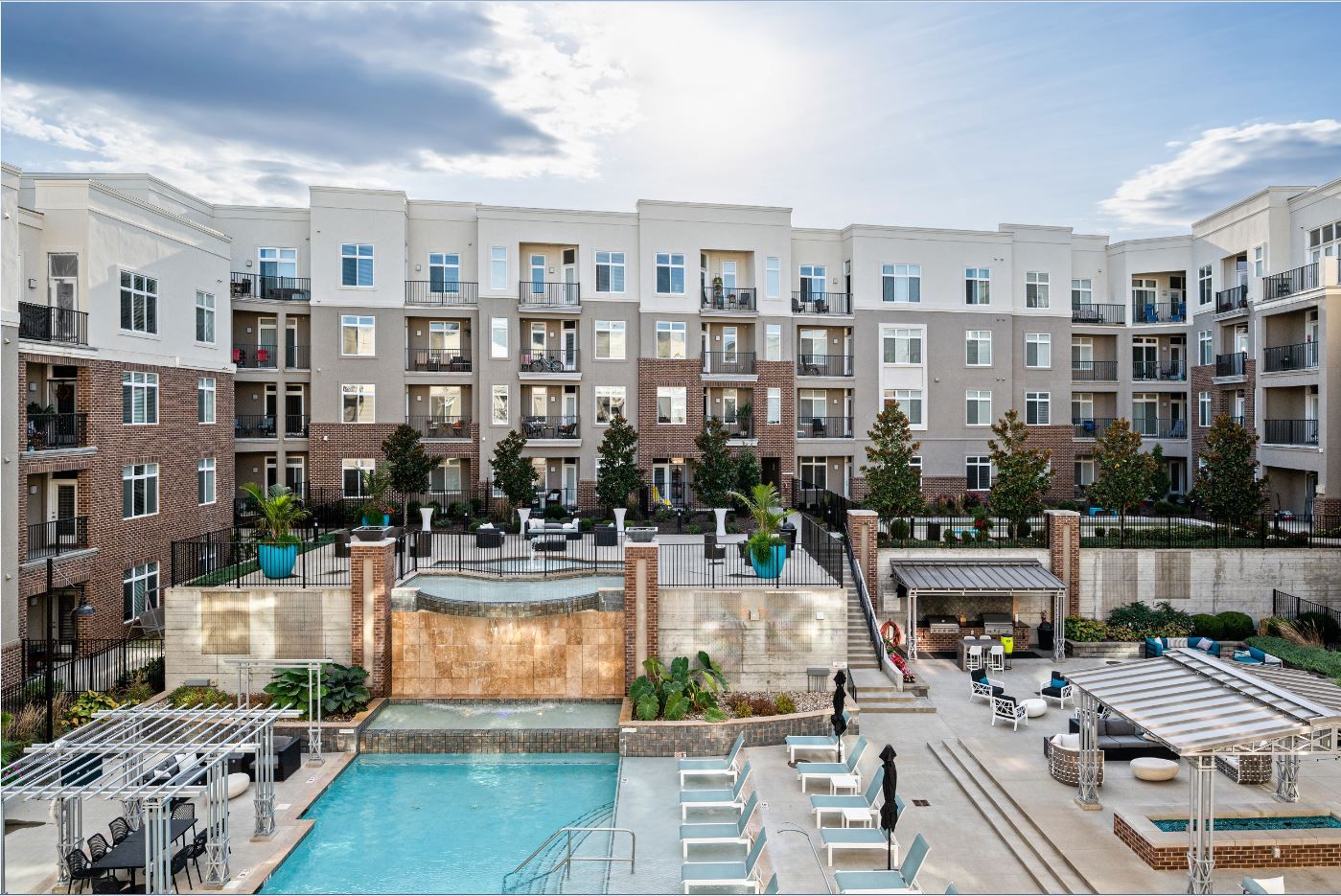 Domain City Center Relaxing pool area in apartment complex, with seating and trees.