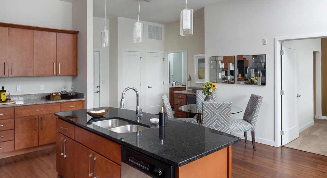 Domain City Center A kitchen with a sink, refrigerator, and a table.